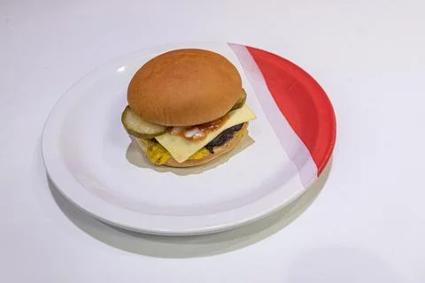 Single hamburger on white plate studio shot Foto stock