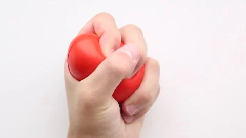 Single hand presses red heart squishy repeatedly 動画素材 314250907