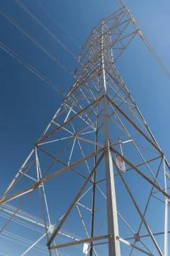 Single high-voltage, high tension power transmission tower, blue sky background Stock Photos