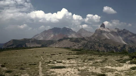 A single hiker proceeds down a high mountain trail Stock Footage 147640603
