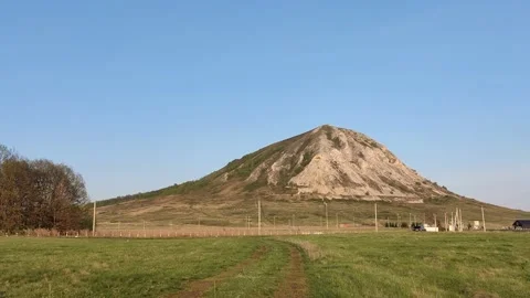Single hill in a field High mountain blue sky Stock Footage 239951626