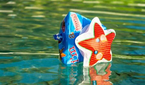 Single inflatable arm float on water with reflection. Stock Photos