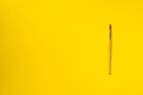Single isolated paint brush flat lay top view yellow background Stock Photos