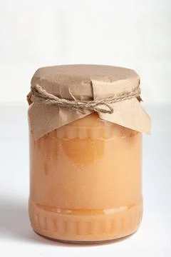 Single jar of apple jam with rustic packaging Stock Photos