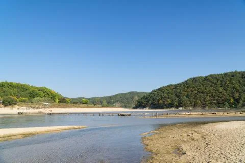 Single lane log bridge over a shallow river Stock Photos