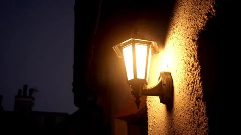 Single lantern burning yellow light is installed on a white light house in the Stock Footage 280874809