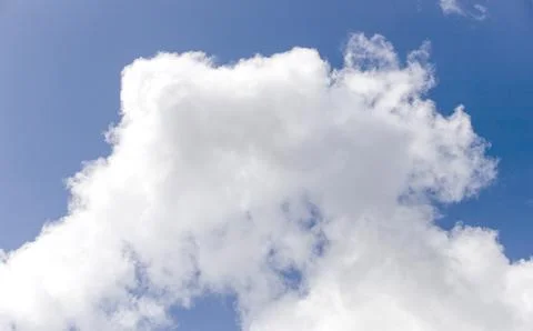 Single large cumulus cloud against blue sky in summer daylight. Soft white .. Stock Photos