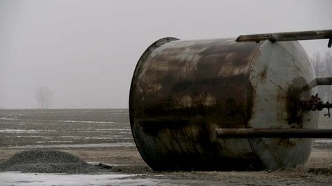 Single Large Water container junked in farm field winter fog Stock Footage 89945134