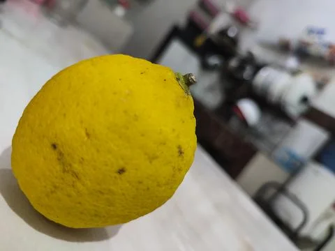 Single lemon rests on clean surface Stock Photos