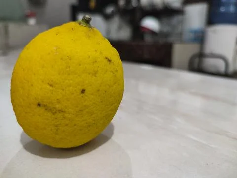 Single lemon rests on clean surface Stock Photos