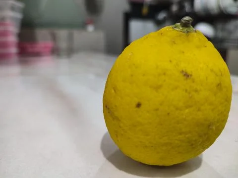 Single lemon rests on clean surface Stock Photos