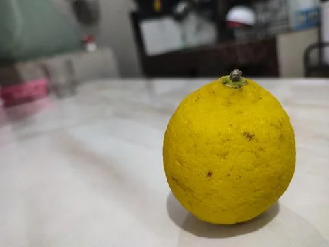 Single lemon rests on clean surface Stock Photos