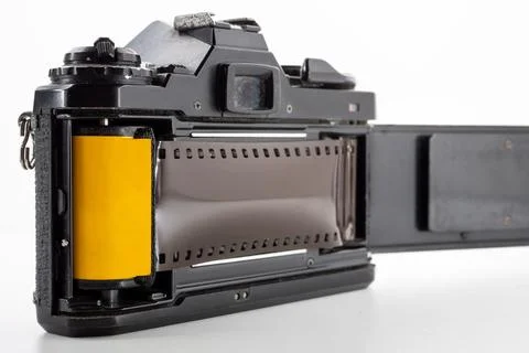 Single lens reflex camera and a film roll on a white background. Stock Photos