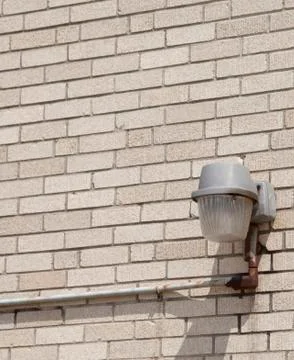 Single light on a bare brick wall Stock-Fotos