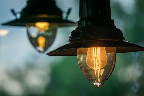 A Single Light Bulb Glowing Brightly Against A Blurry Background Stock Photos