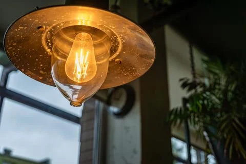 A Single Light Bulb Hanging In A Restaurant Interior Stock Photos