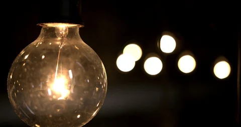Single light bulb with out of focus group of light bulbs in the background Stock Footage 98356840