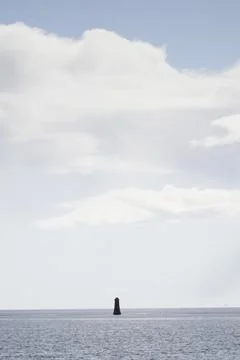 Single lighthouse mindfulness empty background with ocean and blank sky Stock Photos