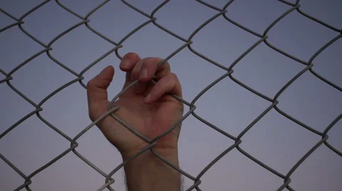 Single Male Hand Pulling Behind Fence Stock Footage 61747776