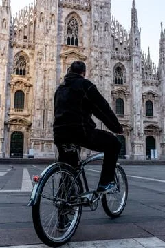 Single man on bicycle standing alone in front of Milan's Cathedral, Duomo MIl Stock Photos