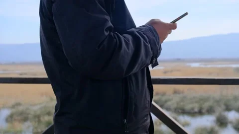 A single man on the bird watching tower and playing with his mobile phone Video stock 153119763