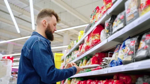 Single man is choosing pasta and spaghetti in supermarket Stock Footage 159887871