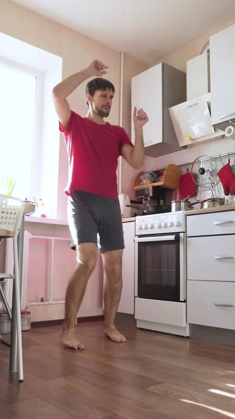 Single man dancing in morning in kitchen, vertical video. Stock Footage 330535159
