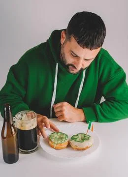 Single man having donuts and stout for breakfast to celebrate St. Patrick's Day Stock Photos
