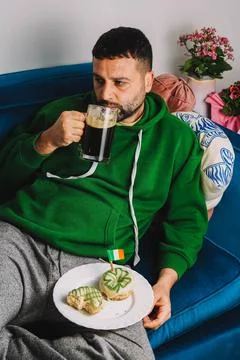 Single man having donuts and stout for breakfast to celebrate St. Patrick's Day Stock Photos