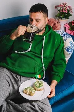 Single man having donuts and stout for breakfast to celebrate St. Patrick's Day Stock Photos