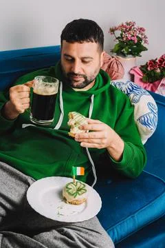 Single man having donuts and stout for breakfast to celebrate St. Patrick's Day Stock Photos