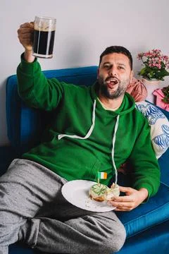 Single man having donuts and stout for breakfast to celebrate St. Patrick's Day Stock Photos