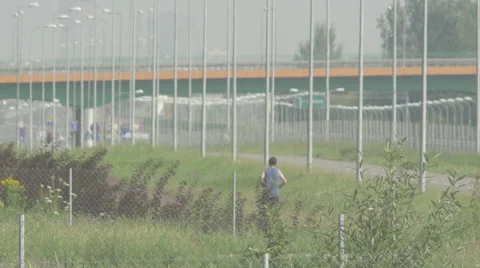 A single man jogging next to a motorway overpass Video stock 63750831