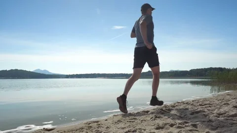 Single man running workout. Daily excercise run near summer lake. Training and w Stock Footage 139015707