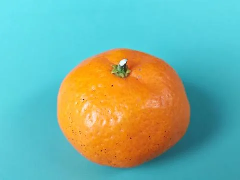 Single Mandarin Fruit on Turquoise Background Foto stock