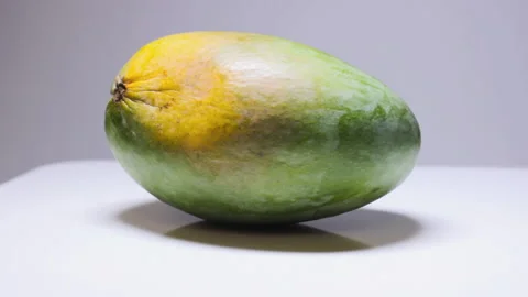 Single mango rotating on white surface, green delicious tropical fruit close up 스톡 동영상 210907462