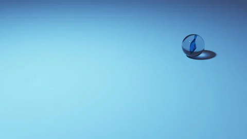 Single marble rolling on a bluish plain ground Stock Footage 220481650