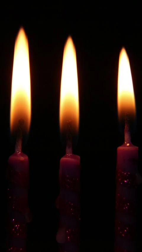 Single match flame gradually ignites multiple candles in sequence on black 動画素材 310738562