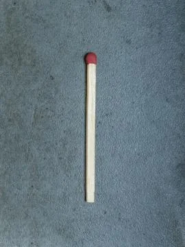 Single matchstick centered on a gray background Stock Photos