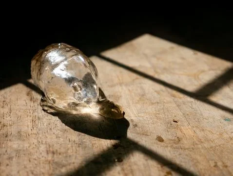 Single melting ice cube on rustic wooden table surface with dramatic sunlig.. Stock Photos