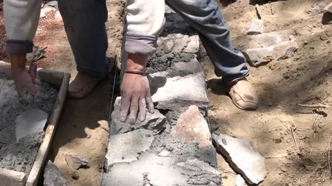 Single mexican construction worker building a small stone wall with rocks Vídeos de archivo 154078658
