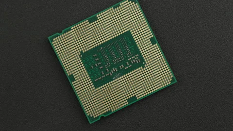 Single Microprocessor with Gold Pins on Textured Dark Surface Видео 337260053