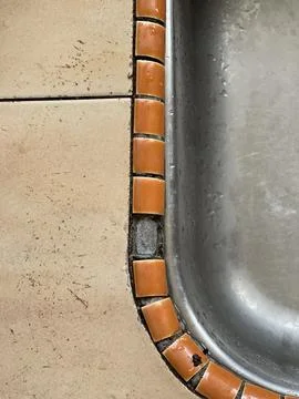 Single Missing Tile And Exposed Mortar On Stainless Steel Kitchen Sink Edge Stock Photos