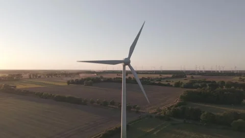Single Modern Wind Turbine Standing Tall in Agricultural Fields at Sunset Stock Footage 342615413