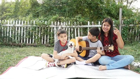 Single mom and sons play guitar together with fun  in the park Stock-Footage 100750941