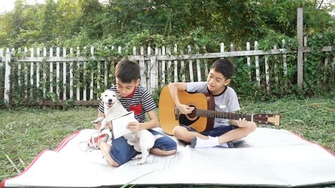 Single mom and sons play guitar together with fun  in the park Stockbeeldmateriaal 100751480