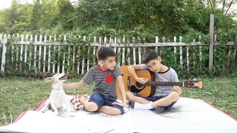Single mom and sons play guitar together with fun  in the park Stockbeeldmateriaal 100751563
