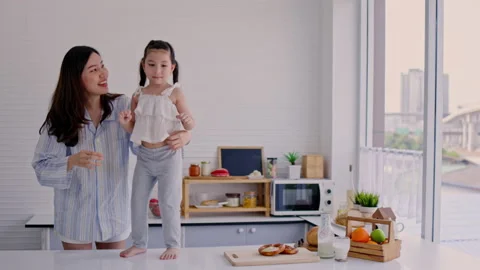 Single mother is dancing with her lovely daughter in her apartment happy. Family Stock Footage 181560978