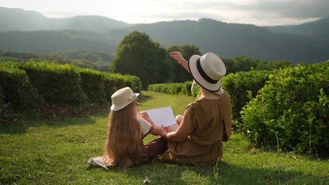 Single mother is spending time with her child in garden, teaching to draw Stock Footage 200836074