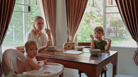 Single mother with two children having breakfast in the kitchen Stock Footage 255230031